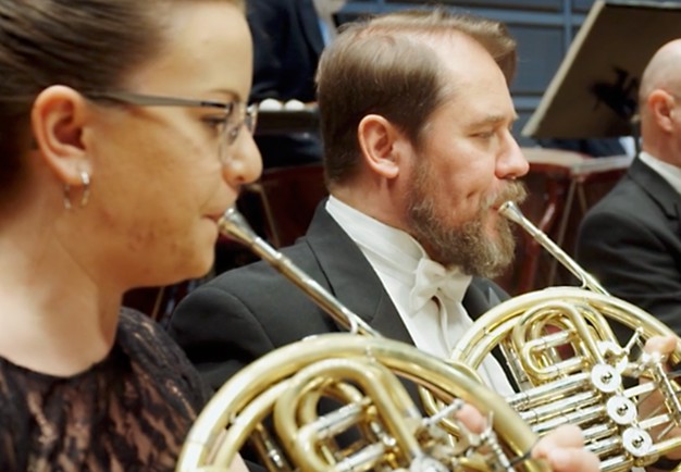 Two musicians playing the horn. From the concert.