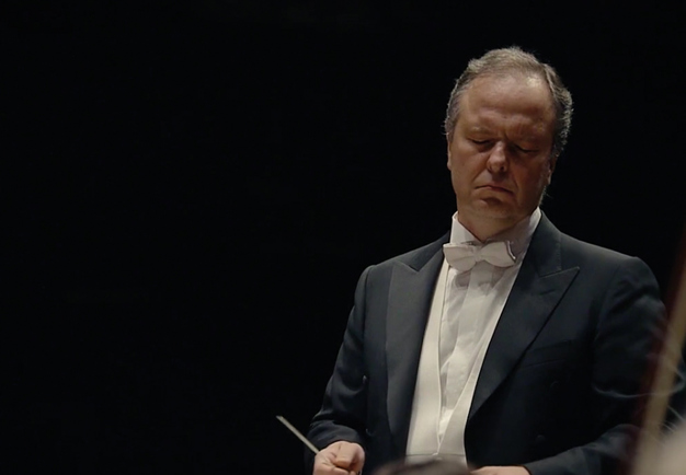 Man conducting with serious face. From the concert. 