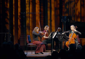 Tre women on the stage in the Grünewald Hall.