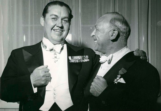 The singer and the conductor laughing together in a dressing-room at Konserthuset. Black and white photograph.