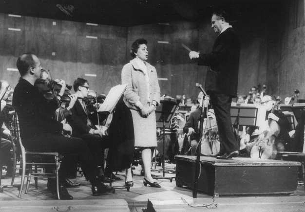 Black and white photo of the orchestra and singer rehearsing.