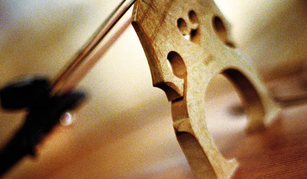 Närbild på cello med stråke