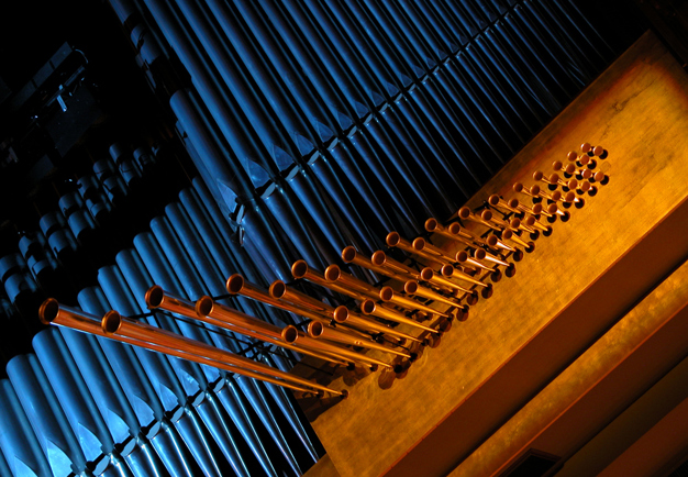 Närbild på KOnserthusets stora orgel i blått sken. Fotografi.