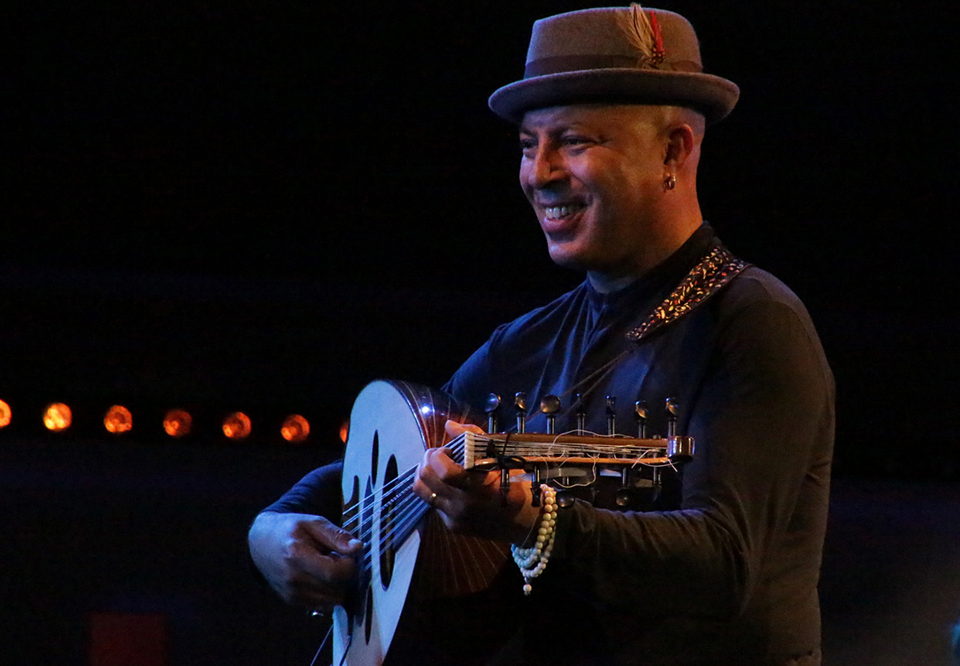 Man standing on stage with his guitar. Photo. 