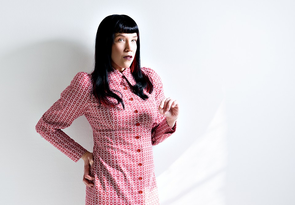 Woman with dark hair and  pink dress. Photo.