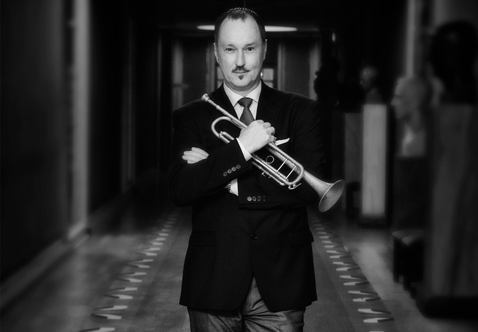 Svart vit bild p åman med trumpet i famnen. Fotografi.