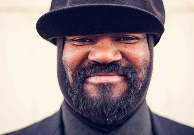 Närbild på en leende Gregory Porter. Huvudbonad. Fotografi.