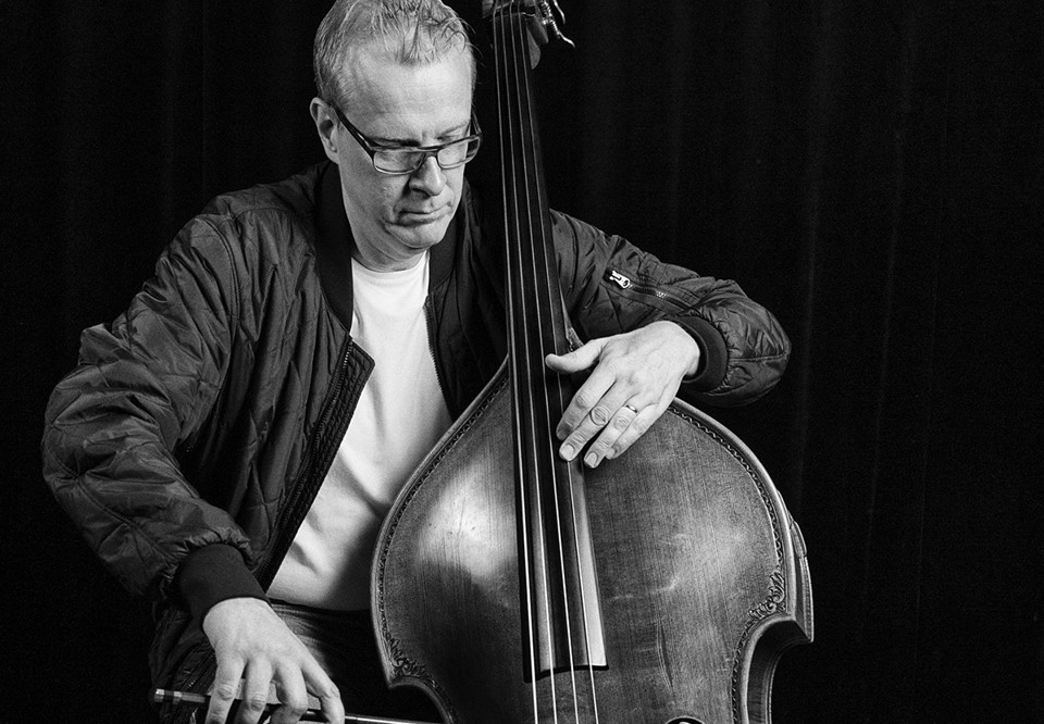 Man som spelar kontrabas. Fotografi.