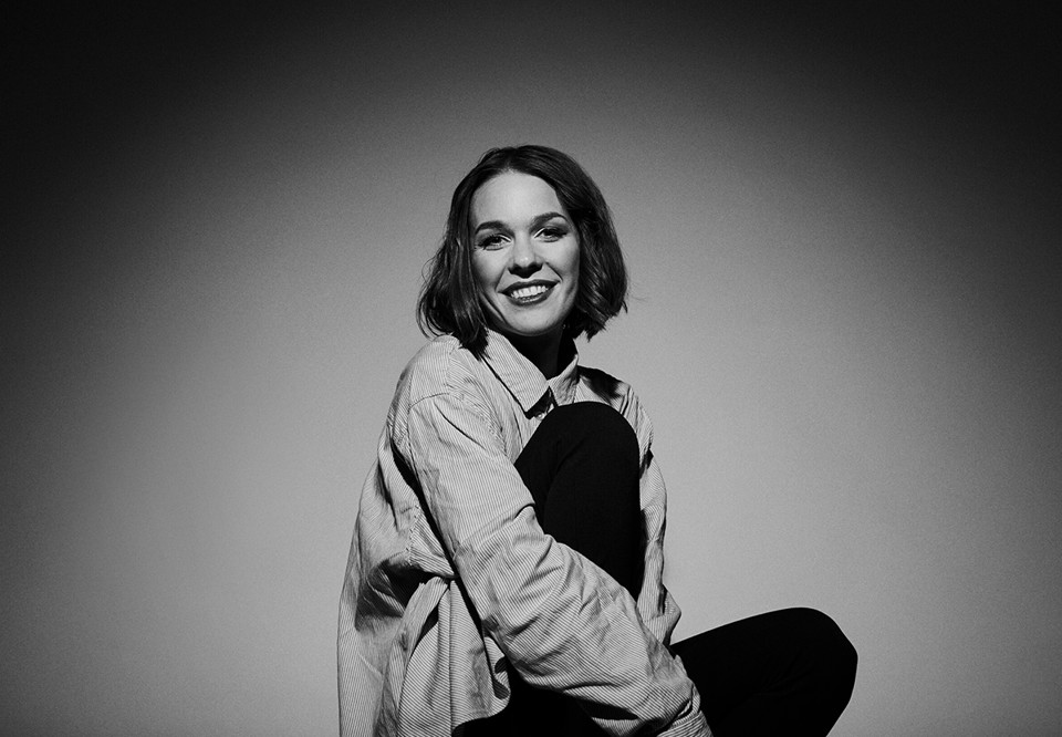 Kvinna som sitter med benet uppdraget. Fotografi.