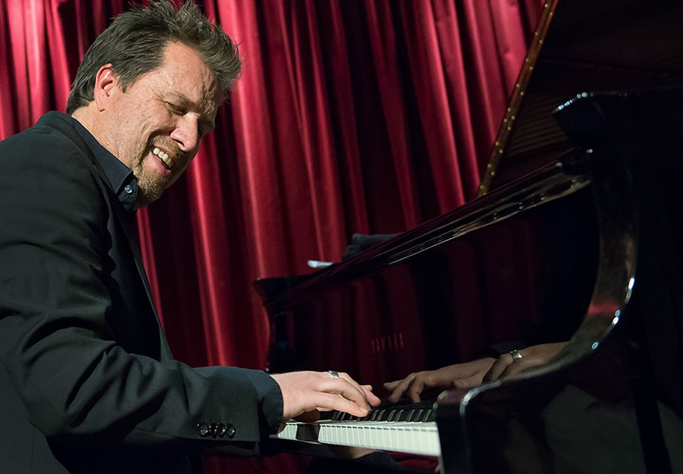 Man som spelar piano. Fotografi.