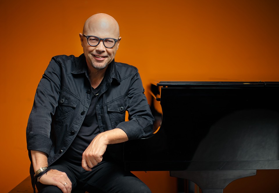 Man sitting by the piano. Photo.