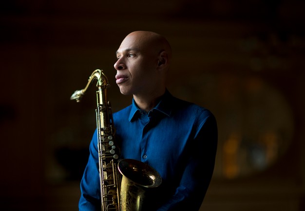 Närbild på man med saxofon. Fotografi.