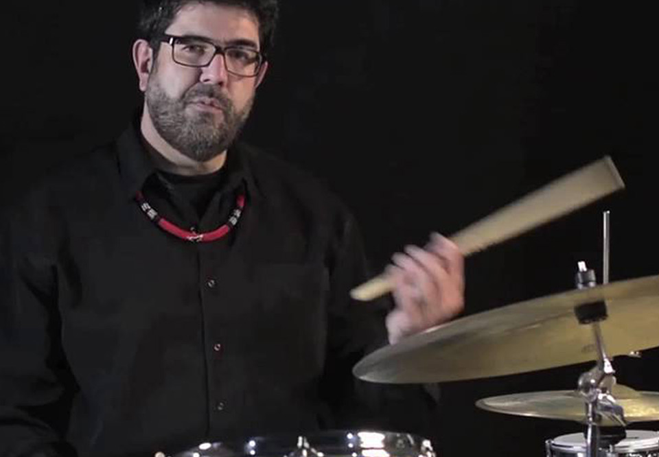 Man sitting behind drum set. Photo.