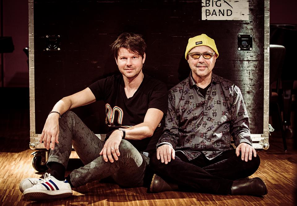 Two men sitting on the floor. Photo.