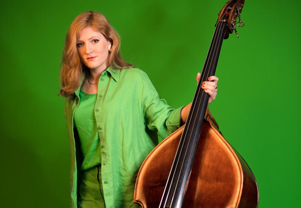 Kvinna som håller i en kontrabas. Fotografi.