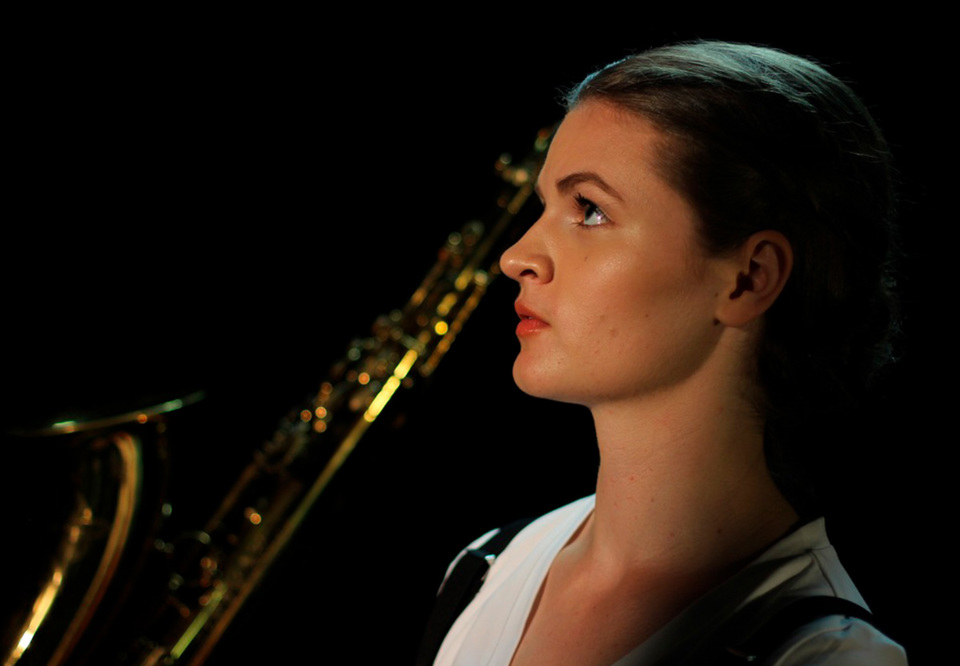 Närbild på kvinna med saxofon. Fotografi.