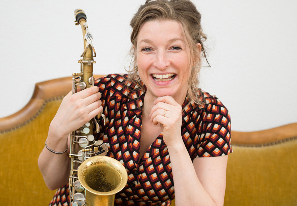 Närbild på kvinna med saxofon. Fotografi.