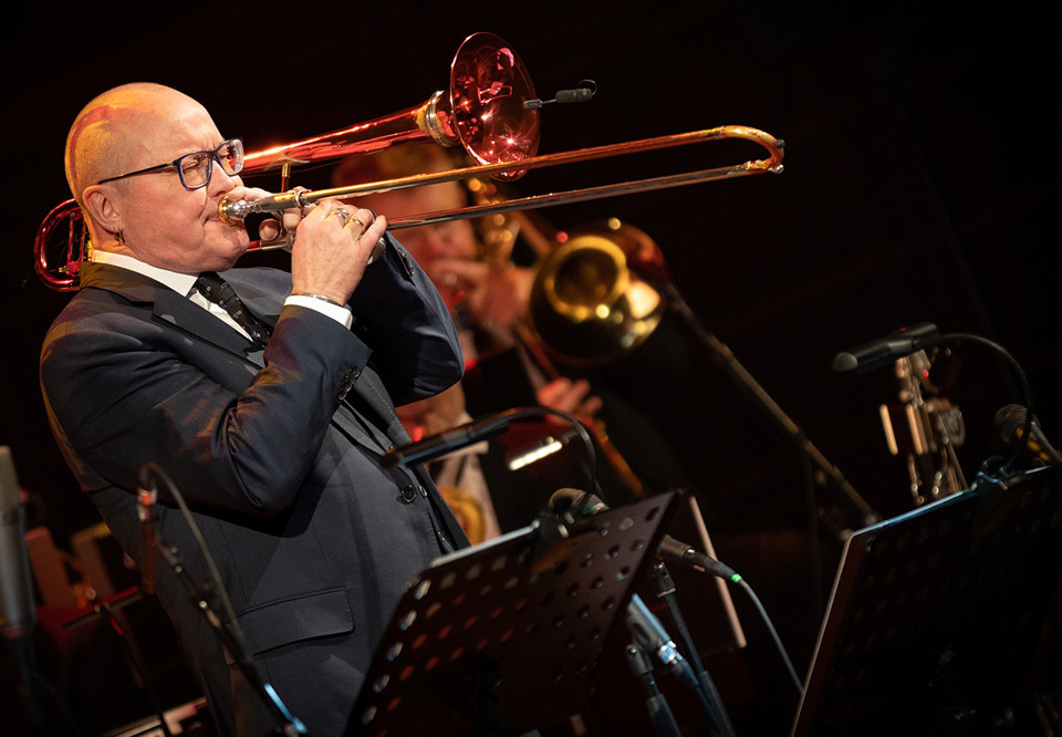 Man som spelar trombon. Fotografi.