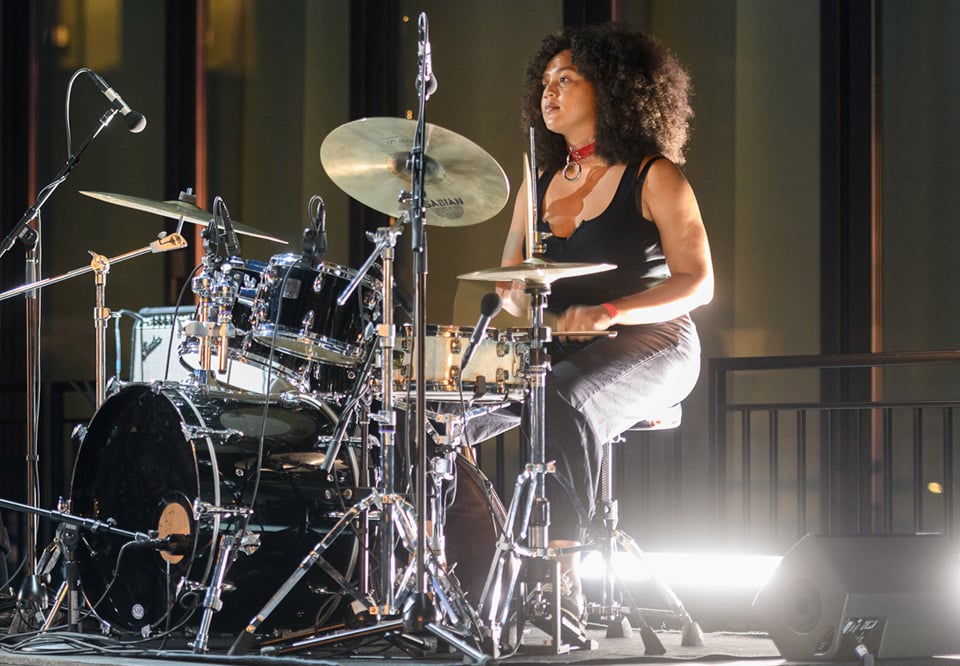 Kvinna som spelar trummor. Fotografi.