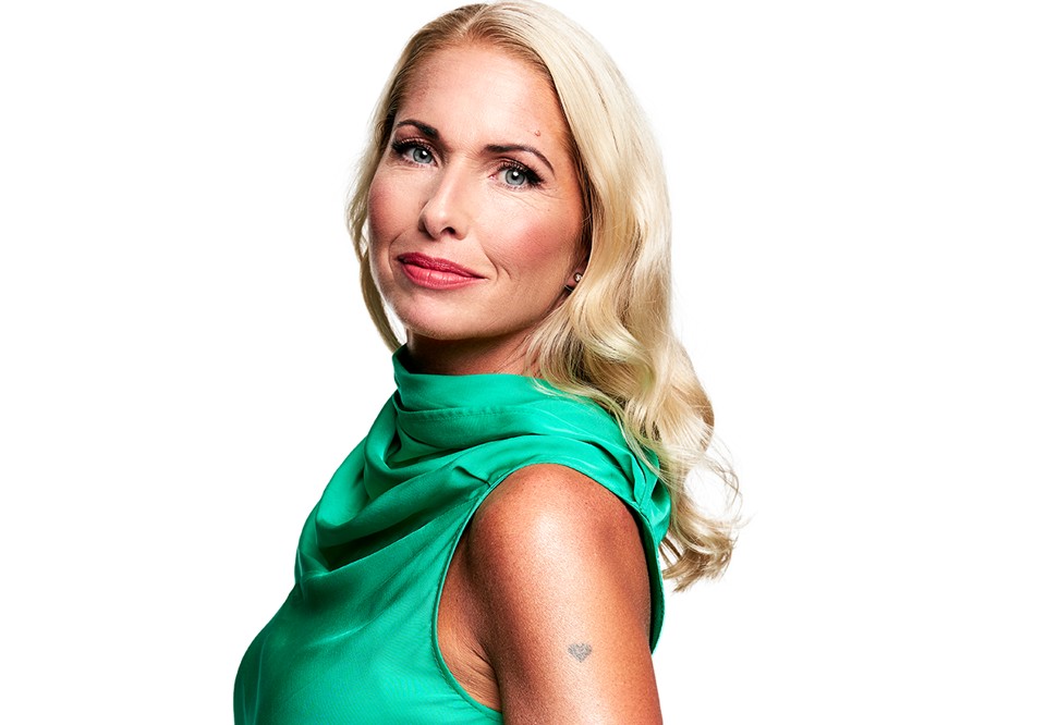 Kvinna med ljust hår som tittar in i kameran. Fotografi.