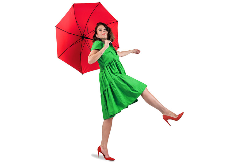 Kvinna som går med ett paraply. Fotografi.