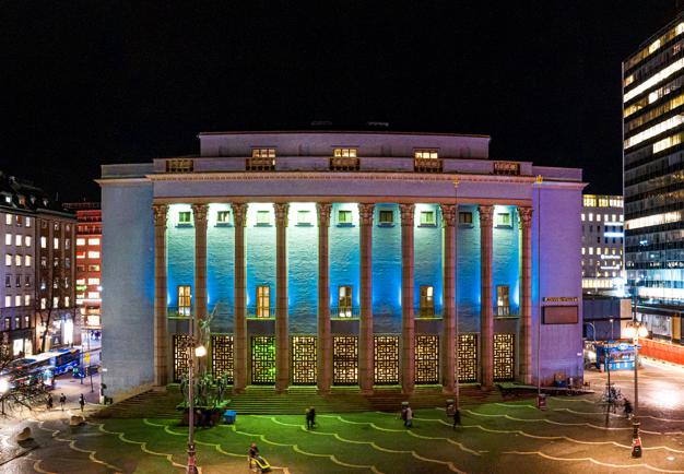 Fotografi upp mot Konserthusets pelarfasad och blå himmel.