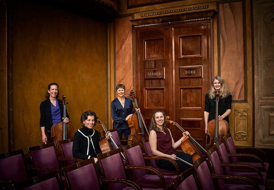 Kvinnor som håller i varsin cello. Fotografi.