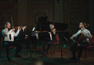 Fyra musiker som sitter ner och spelar. Utdrag ur filmen. 
