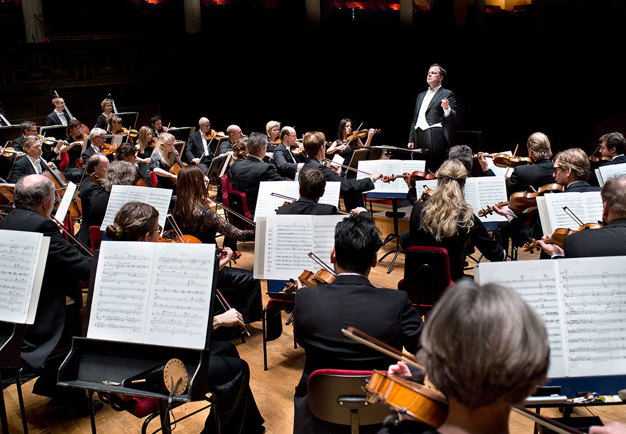 Conductor in front of a large orchestra. Photoo.