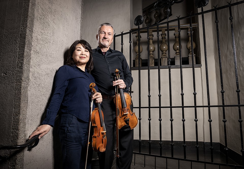 Two musicians standing with their instruments. Photo.