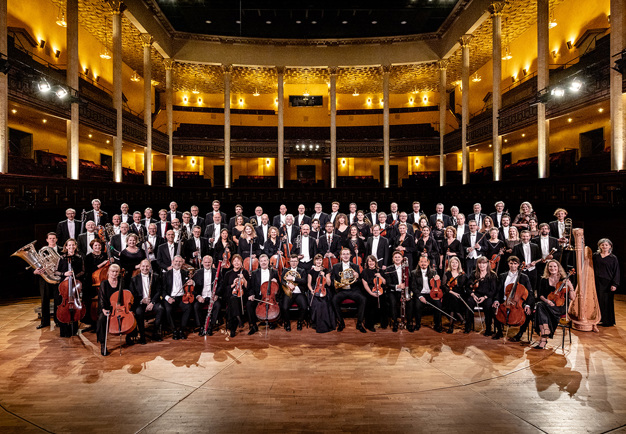 Stor orkester på podiet. Fotografi.