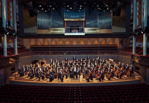 The orchestra's one hundred and five musicians on stage. Photo.