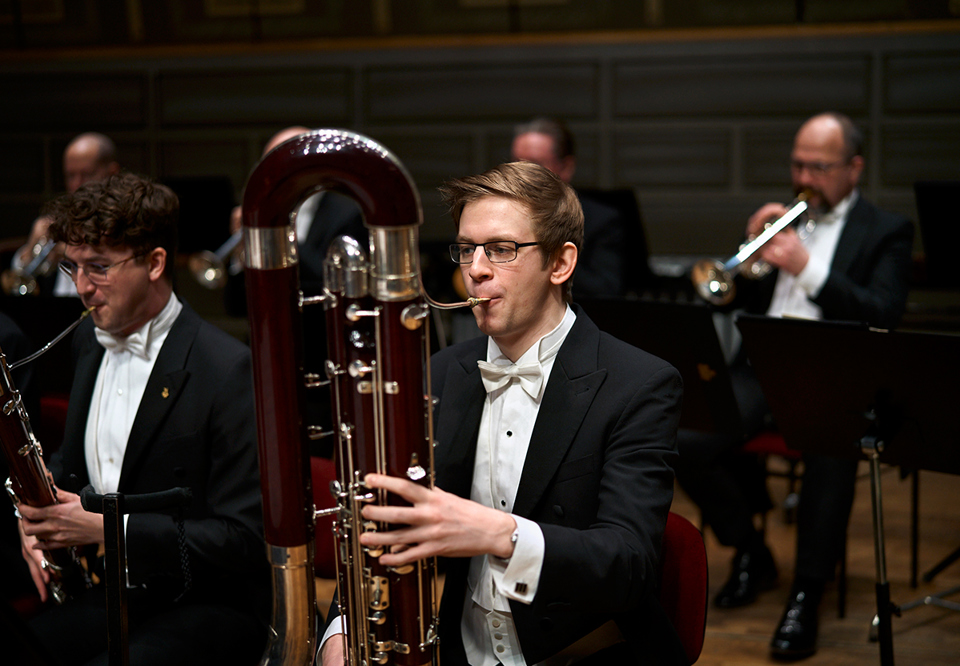 Fotografi på konsertklädda musiker i träblåsstämman. 