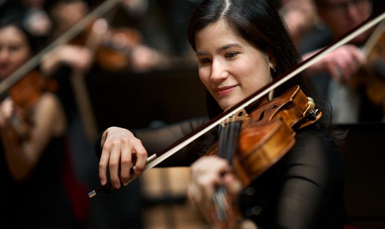 Kvinna som spelar violin. Fotografi.