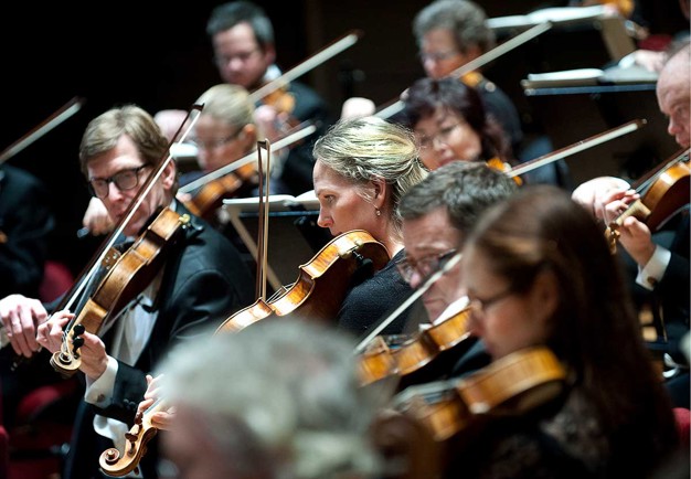 Spelande orkestermusiker. Fotografi.