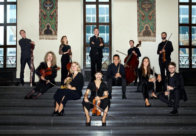 Musicians sitting with their instrument. Photo.