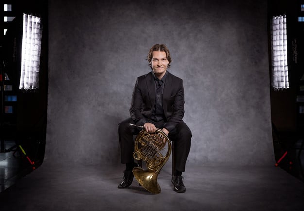 Glad kille med instrument. Fotografi.