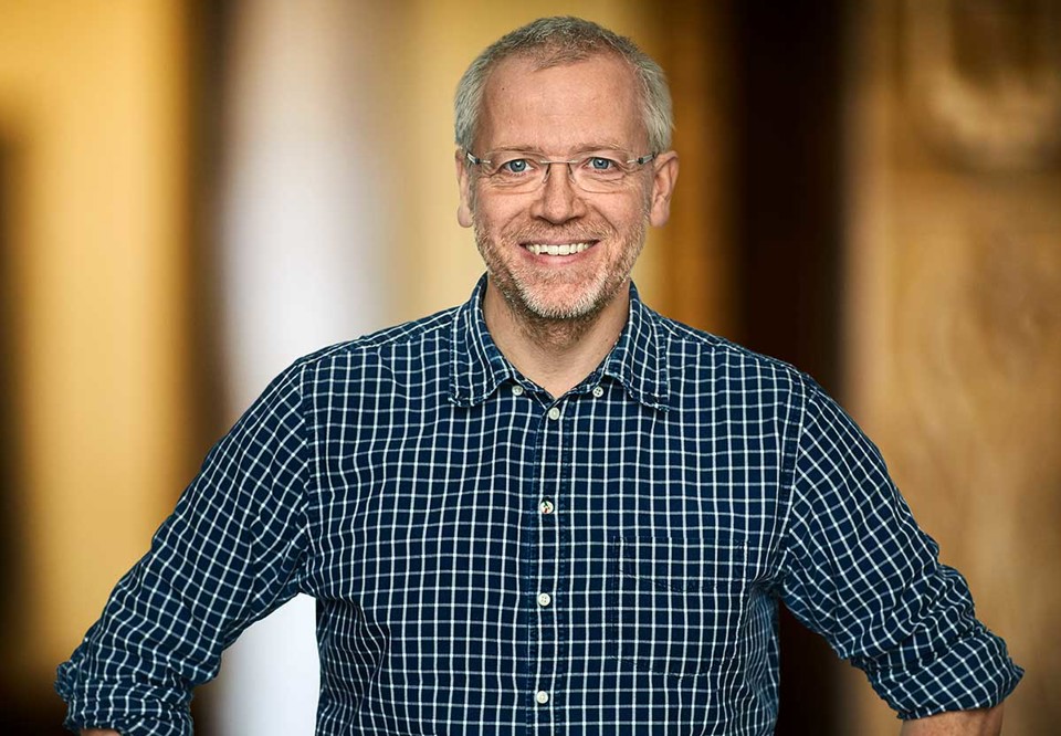 Daniel ler ch ser in i kameran. Porträttfotografi.