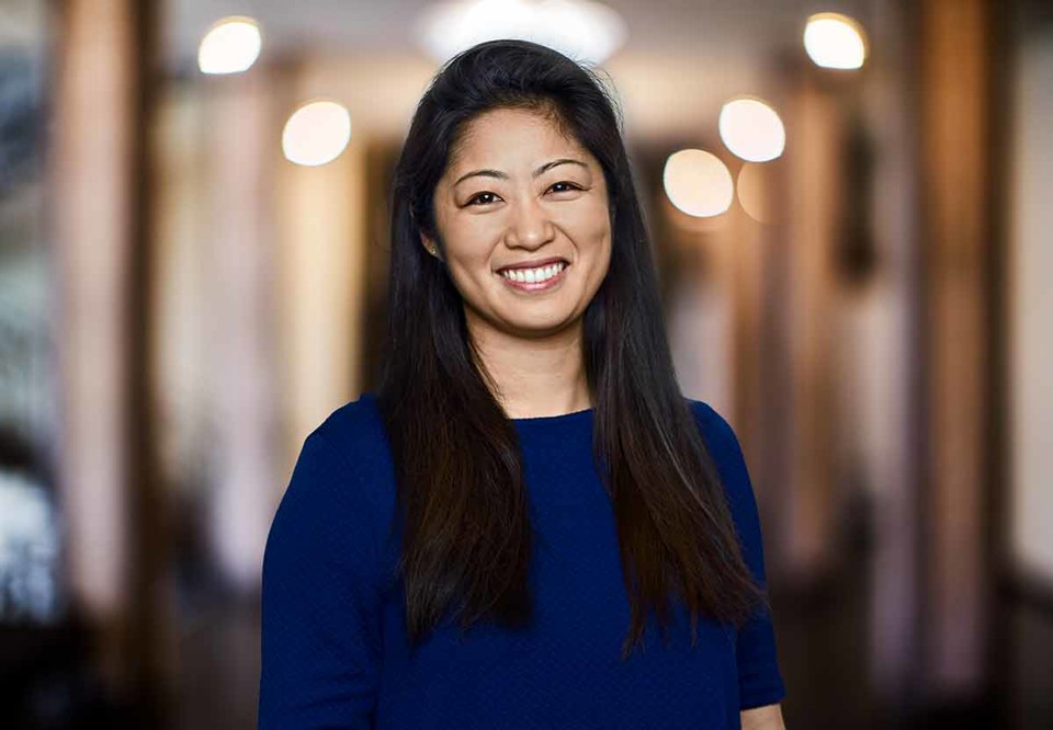 Dark-haired woman with long hair. Looking into the camera and smiling. Photo.