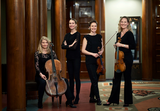 Fyra kvinnor som står med sina instrument. Fotografi.