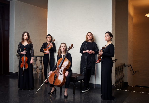 Five women standing with their instruments. Photo.