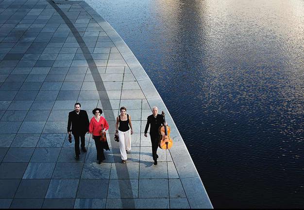 Quartet walking on a street. Photo.