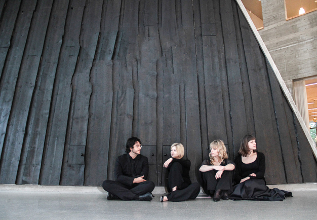 Four people sitting down. Photo.