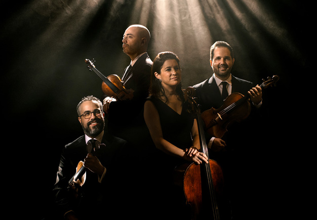 Fyra musiker som håller i sina instru,´ment. Fotografi.