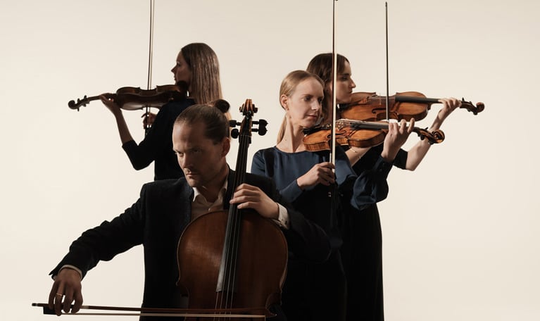 Fyra musiker som spelar. Fotografi.