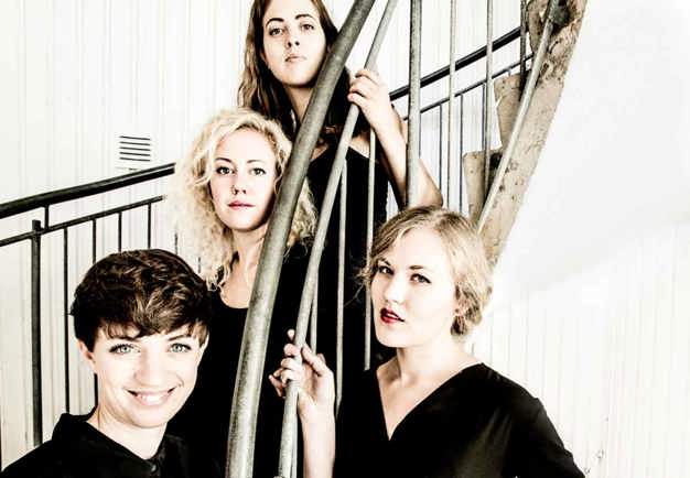 Four girls standing in a staircase. Photography.