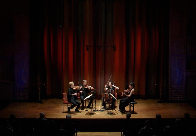 Fyra musiker som spelar. Fotografi.