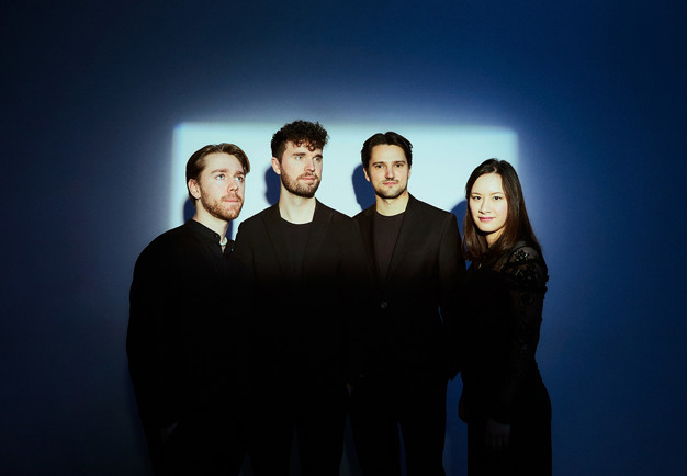 Fyra musiker på rad. Fotografi.