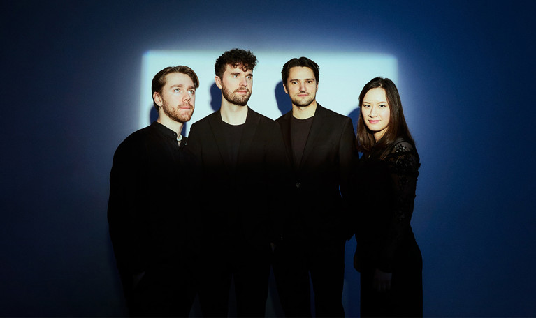 Fyra musiker på rad. Fotografi.