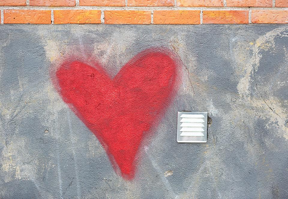 Målat rött hjärta på en mur. Fotografi.